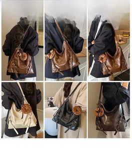 Close-up of hobo bag featuring doughnut charm and adjustable metal buckles on side