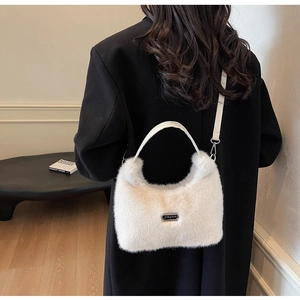 Détail du sac à bandoulière en peluche crème avec plaque logo et chaîne en métal