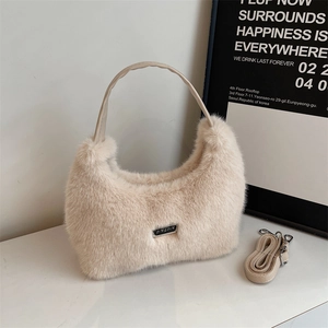 Détail du sac à main beige en fausse fourrure avec plaque argentée et texture pelucheuse