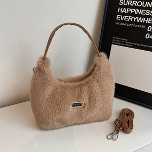 Détail du sac hobo en fausse fourrure marron avec plaque logo et bandoulière