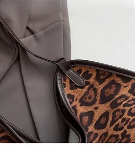 Close-up of leopard print suede material with brown leather edges and fine stitching