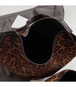 Detail view of the large capacity leopard print tote with open top and leather handles