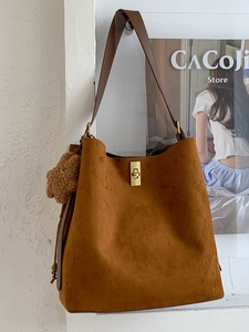 Brown suede tote bag with metal twist lock and plush bear charm for daily commuting