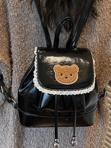 Retro black faux leather mini backpack with lace trim and cute bear on a model