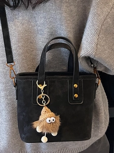 Elegante borsa a secchiello nera con ciondolo mostro di peluche e tracolla regolabile