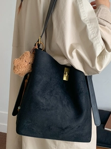 Minimalist black suede bucket tote bag with gold twist lock and a cute teddy bear charm