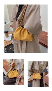 Detail view of yellow suede pleated dumpling bag with soft textures and shoulder strap