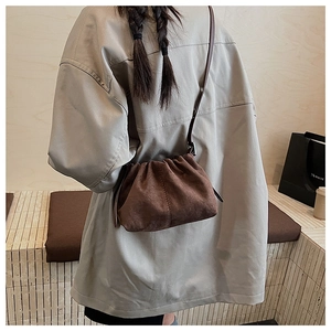 Deep brown suede shoulder bag featuring a pleated top and minimalist leather strap design