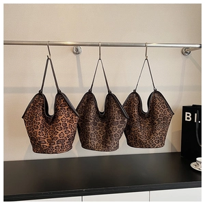 Detailed comparison of three leopard print hobo bags hanging on a display rack