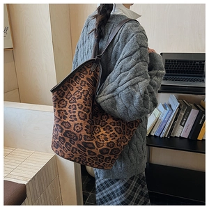 Detailed back view of a large leopard print tote bag with brown leather shoulder straps