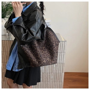 Detail of leopard print tote bag with black handles styled with a leather jacket