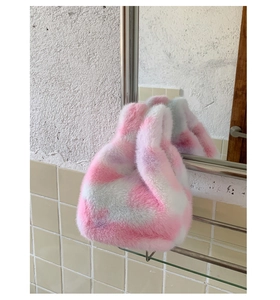 Detail of plush faux fur handbag with pink and white marbled pattern on metal rack