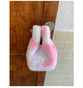Detailed texture of pink and white faux rabbit fur mini tote bag with gold metal D-ring