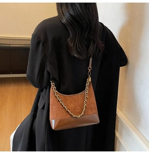 Close-up of vintage brown color-block shoulder bag with chunky gold metal chain detail