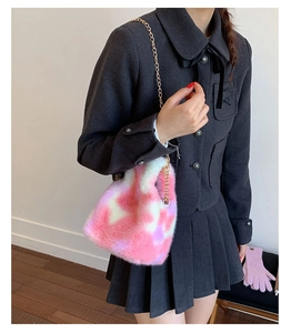 Detail of plush faux fur handbag with pink tie-dye texture and gold chain strap