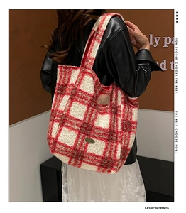Detail of red and white striped plush tote bag featuring a metallic handmade plaque
