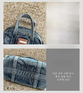 Detailed view of reinforced stitching and brown leather logo on blue denim handbag