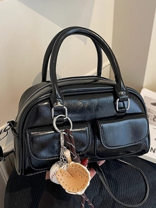 Glossy black Boston handbag with baseball charms and adjustable crossbody shoulder strap