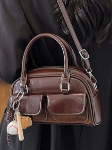 Glossy chocolate brown Boston bag with sports charm and stylish crossbody strap for women