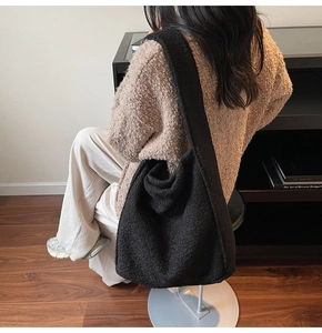 Gros plan sur le sac fourre-tout en polaire noire pour un look d'automne décontracté