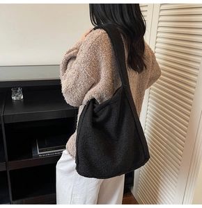 Détail du tissu en polaire noire du sac hobo avec une large bandoulière