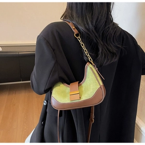 Model wearing a vintage green and brown baguette bag over a black blazer back view