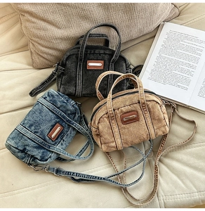 Detailed macro view showing vintage washed denim bags in navy, grey, and brown colors