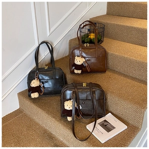 Nahaufnahme der Vintage PU Leder Boston Taschen in verschiedenen Farben mit Bärenanhängern