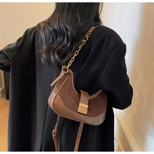 Detailed back view of a brown suede and leather patchwork half-moon bag with gold chain strap