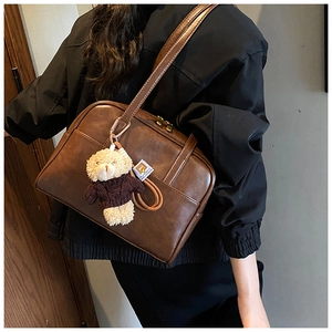 Detail der braunen Retro PU-Schultertasche mit Bärenanhänger und Doppelreißverschluss