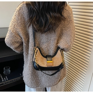 Detail view of a vintage French baguette bag worn as a shoulder bag with a gold chain strap