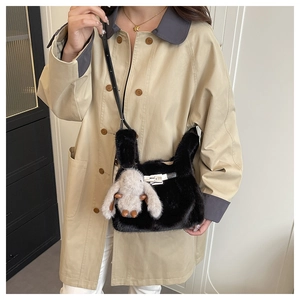 Détail du sac bandoulière en peluche noire avec charm lapin beige et boucle en métal