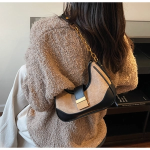 Detail of hobo bag with beige wool fabric, black leather trim and gold chain strap
