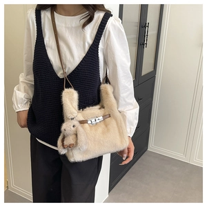 Détail du sac seau en peluche beige avec fermoir en métal et breloque lapin