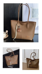 Close-up of brown litchi grain leather tote bag with stylish bear pendant and shoulder straps