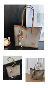Detailed view of grey pebble leather tote with brown trim and bear charm accessory