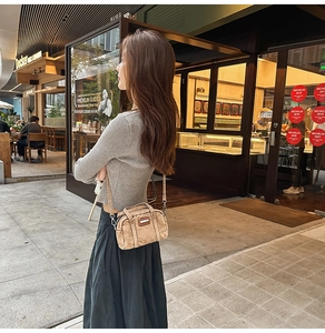 Detail of vintage washed denim crossbody bag in light brown worn by a female model outdoors