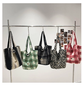 Assortment of fleece tote bags in checkered and leopard patterns on a metal rack