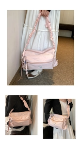 Détails de la bandoulière plissée et du logo ours en métal sur le sac en nylon rose