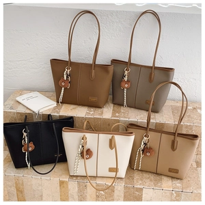 Detailed view of five colorful leather tote bags with minimalist design and shoulder straps