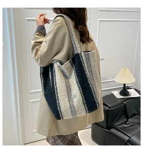 Close-up of a striped plush tote bag with soft faux fur texture and twin shoulder straps
