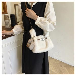 Détail du sac bandoulière en peluche blanche avec sangle en cuir et pendentif lapin
