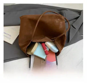 Macro detail showing spacious interior of the brown suede tote bag with daily essentials