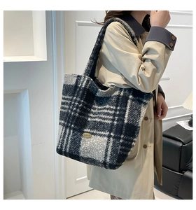 Detail of grey plaid plush tote bag texture with handmade metal plate on wool fabric