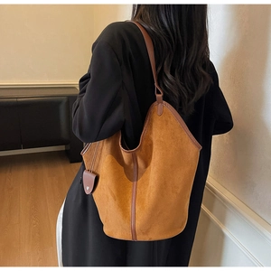 Detail of caramel brown suede tote bag showing large capacity and smooth leather handle