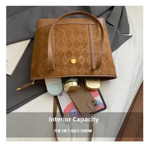 Detail view of brown tote bag interior capacity with laptop, phone and cosmetics