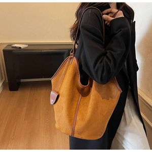 Detail view of large brown suede tote bag with leather trim and matching hanging pouch