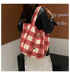Detail of red and white checkered plush tote bag with cozy fleece texture and metal logo