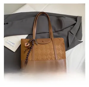 Detailed macro of the vintage brown tote showing embossed diamond pattern and textures