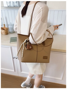 Detailed view of brown lychee grain tote bag featuring a cute plush bear charm